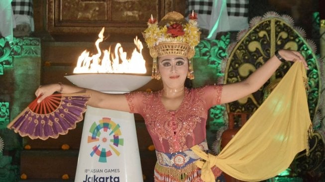 Legenda bulu tangkis Indonesia Susi Susanti  didampingi Kepala Istana Kepresidenan Tampaksiring I Dewa Gde Swarthana berlari membawa obor saat pawai obor (torch relay) Asian Games 2018 di Istana Kepresidenan Tampaksiring, Gianyar, Bali, Senin (23/7). Pawai Obor Asian Games 2018 di Pulau Dewata melintasi sejumlah lokasi antara lain Istana Kepresidenan Tampaksiring dan beberapa objek wisata di sejumlah kota/kabupaten. ANTARA FOTO/Fikri Yusuf