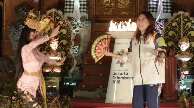 Legenda bulu tangkis Indonesia Susi Susanti  didampingi Kepala Istana Kepresidenan Tampaksiring I Dewa Gde Swarthana berlari membawa obor saat pawai obor (torch relay) Asian Games 2018 di Istana Kepresidenan Tampaksiring, Gianyar, Bali, Senin (23/7). Pawai Obor Asian Games 2018 di Pulau Dewata melintasi sejumlah lokasi antara lain Istana Kepresidenan Tampaksiring dan beberapa objek wisata di sejumlah kota/kabupaten. ANTARA FOTO/Fikri Yusuf