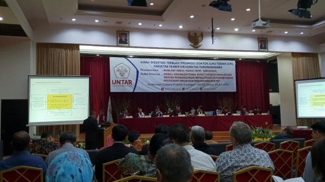 Direktur Jenderal Penyediaan Perumahan Kementerian PUPR, Khalawi Abdul Hamid, saat melakukan Ujian Disertasi Terbuka Promosi Doktor Ilmu Teknik Sipil Fakultas Teknik Universitas Tarumanegara, Jakarta, Selasa (24/7/2018). (Dok: Kementerian PUPR)