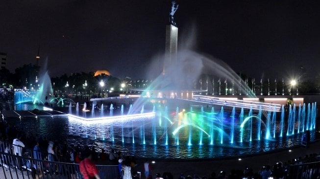 Pengunjung menyaksikan air mancur menari saat peresmian revitalisasi lapangan Banteng di Jakarta, Rabu (25/7). Pemprov DKI Jakarta secara resmi membuka kawasan lapangan Banteng yang telah direvitalisasi untuk dapat diakses oleh masyarakat. ANTARA FOTO/Wahyu Putro 