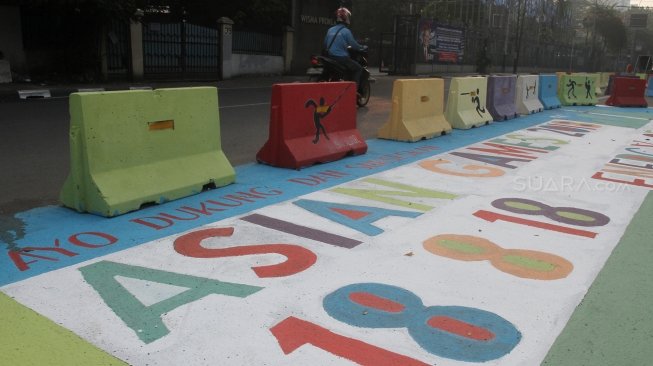 Pengendara melintas di Jalan Proklamasi yang telah dihiasi mural bertema  Asian Games, Jakarta Pusat, Jumat(27/7). Selain untuk menyambut Asian Games mural tersebut dibuat sebagai sosialisasi kepada masyarakat untuk mendukung perhelatan Asian Games 2018 Agustus mendatang