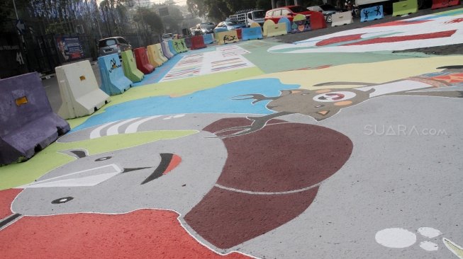 Pengendara melintas di Jalan Proklamasi yang telah dihiasi mural bertema  Asian Games, Jakarta Pusat, Jumat(27/7). Selain untuk menyambut Asian Games mural tersebut dibuat sebagai sosialisasi kepada masyarakat untuk mendukung perhelatan Asian Games 2018 Agustus mendatang