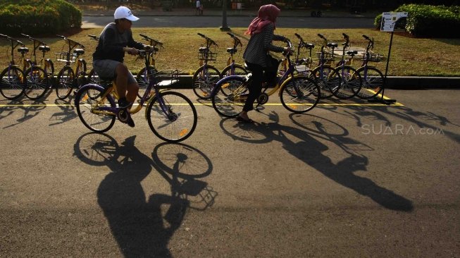 Pengunjung menggunakan sepeda dari layanan bike sharing di Monas, Jakarta, Jumat (27/7). Unit Pengelola Kawasan Monumen Nasional dan Unit Pengelola Jakarta menyediakan layanan bike sharing berbasis aplikasi, untuk para pengunjung yang ingin menjelajahi seluruh kawasan Monas ada 100 sepeda dari 7 titik. Layanan itu merupakan kerja sama antara Smart City dan GOWES selaku operator bike sharing. [suara.com/Muhaimin A Untung]