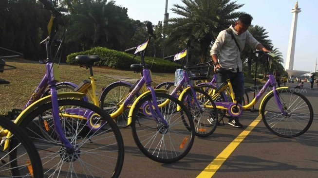 Pengunjung menggunakan sepeda dari layanan bike sharing di Monas, Jakarta, Jumat (27/7). Unit Pengelola Kawasan Monumen Nasional dan Unit Pengelola Jakarta menyediakan layanan bike sharing berbasis aplikasi, untuk para pengunjung yang ingin menjelajahi seluruh kawasan Monas ada 100 sepeda dari 7 titik. Layanan itu merupakan kerja sama antara Smart City dan GOWES selaku operator bike sharing. [suara.com/Muhaimin A Untung]