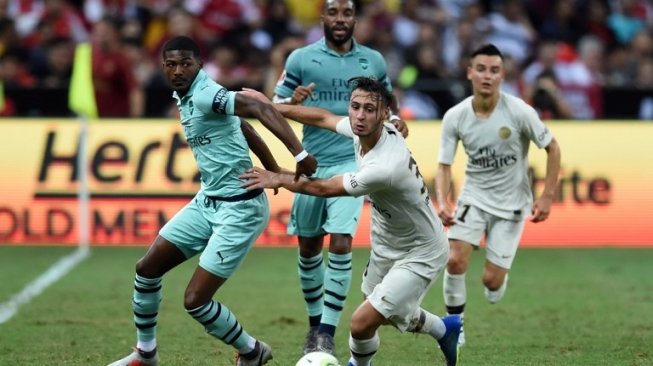 Gelandang muda PSG, Azzedine Toufiqui (tengah), berebut bola dengan pemain tengah Arsenal, Ainsley Maitland-Niles (kiri), dalam laga International Champions Cup di Singapura, Sabtu (28/7/2018). [AFP/Roslan Rahman]