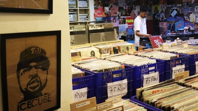 Pengunjung memilih piringan hitam di sebuah toko musik Paper Pot Record di kawasan Blok M, Jakarta, Minggu (29/7). Toko tersebut mengobral koleksi piringan hitam yang diproduksi pada tahun 1950-an dengan harga Rp75 ribu hingga Rp200 ribu per keping, totalnya dengan koleksi sekitar 10.000 pirangan hitam. [Suara.com/Oke Dwi Atmaja]