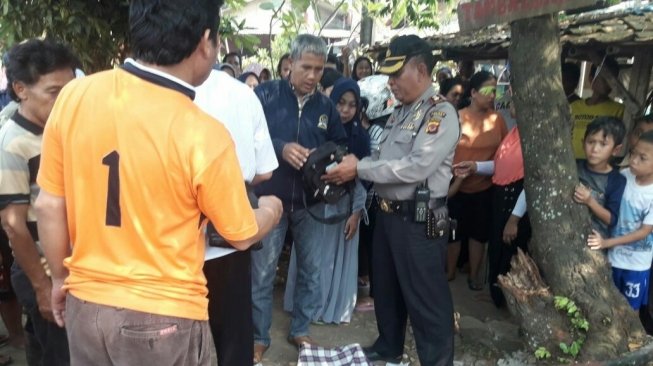 Kakek penjual cilok tewas di depan kios tambal ban, di Bogor, Jawa Barat, Sabtu (28/7/2018). [Suara.com/Rambiga]