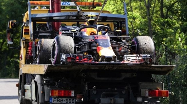 Mobil tim F1 Red Bull Racing yang dikemudikan Max Verstappen diangkut oleh mobil truk setelah mengalami kerusakan mesin pada balapan F1 GP Hungaria, Minggu (29/7/2018). [AFP/Ferenc Isza]