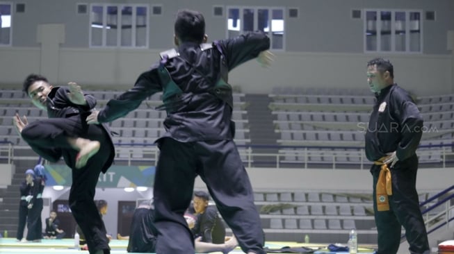 Pelatih Tim Pencak Silat Indonesia, Abas Akbar (kanan), memantau latihan para pesilat Indonesia di Padepokan Pencak Silat, Taman Mini, Jakarta, dalam persiapan menuju Asian Games 2018. [Suara.com/Dendi Afriyan]