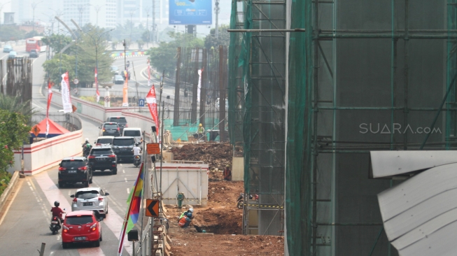 Pekerja menyelesaikan proyek light rail transit atau LRT yang melintas di Jl Rasuna Said, Jakarta, Selasa (31/7). Kereta ringan Jabodebek ditargetkan beroperasi pada Mei 2019 yang bakal melintasi tiga rute atau lintasan, yakni dari Cibubur menuju Cawang, Bekasi Timur menuju Cawang, dan Cawang menuju Dukuh  Atas belum dapat dipakai saat perhelatan akbar Asian Games. [suara.com/Muhaimin A Untung].