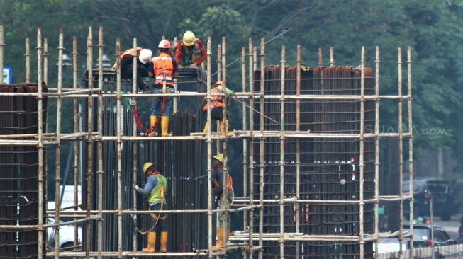 Pekerja menyelesaikan proyek light rail transit atau LRT yang melintas di Jl Rasuna Said, Jakarta, Selasa (31/7). Kereta ringan Jabodebek ditargetkan beroperasi pada Mei 2019 yang bakal melintasi tiga rute atau lintasan, yakni dari Cibubur menuju Cawang, Bekasi Timur menuju Cawang, dan Cawang menuju Dukuh  Atas belum dapat dipakai saat perhelatan akbar Asian Games. [suara.com/Muhaimin A Untung].