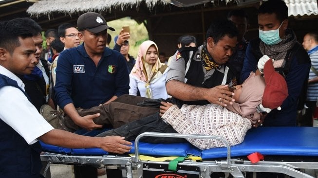 Petugas mengevakuasi pendaki Gunung Rinjani yang sempat terjebak longsor akibat gempa bumi di Pos Bawaknao, Sembalun, Lombok Timur, NTB, Senin (30/7). Sebanyak 560 pendaki sempat terjebak di Gunung Rinjani akibat gempa bumi yang terjadi pada hari minggu (29/7). [ANTARA FOTO/Akbar Nugroho Gumay]