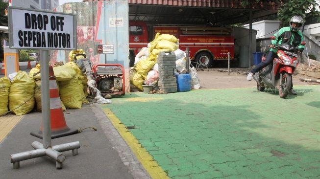 Pengemudi ojek online berada di tempat drop off yang disediakan di Balai Kota DKI Jakarta, Rabu (1/8). Pemprov DKI menginstruksikan adanya tempat pemberhentian khusus bagi ojek online di kantor-kantor Pemprov DKI. [Suara.com/Oke Dwi Atmaja].