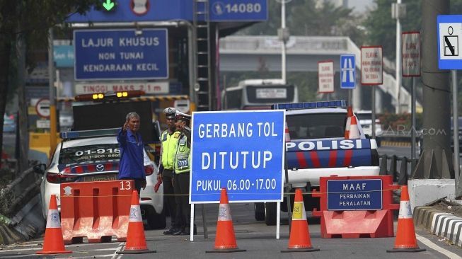 Dirlantas Polda Metro Jaya bersama Dinas Perhubungan DKI Jakarta menjaga pintu gerbang tol yang ditutup di Tol Slipi 2, Jakarta, Rabu (1/8). Penutupan pintu tol secara permanen di 19 pintu tol tersebut demi kelancaran transportasi penyelenggaraan Asian Games 2018 agar waktu tempuh perjalanan atlet dari wisma atlet menuju veneu cuma 30 menit. [suara.com/Muhaimin A Untung].