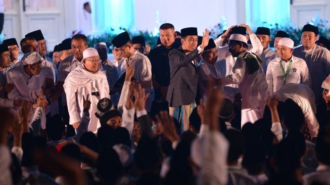 Presiden Joko Widodo memberikan sambutan pada acara zikir dan doa untuk bangsa di halaman Istana Merdeka, Jakarta, Rabu (1/8). Dalam kegiatan zikir dan doa yang diikuti ratusan alim ulama serta masyarakat tersebut Presiden Joko Widodo mengingatkan masyarakat Indonesia untuk terus menjaga persaudaraan dan persatuan bangsa. [ANTARA FOTO/Wahyu Putro]