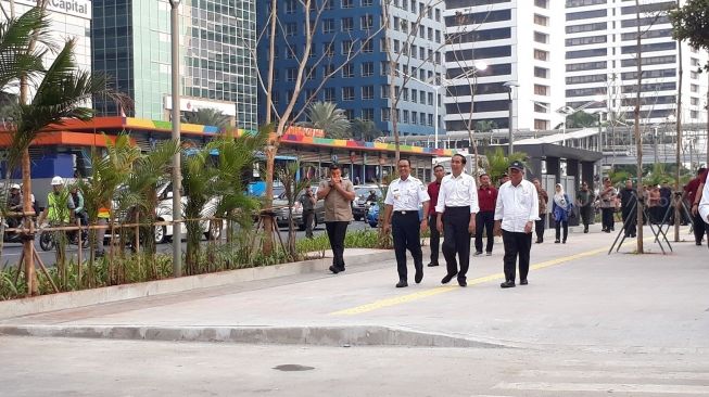 Presiden Joko Widodo dan Gubernur DKI Jakatya Anies Baswedan menyeberang di pelican crossing Bundaran HI. (Suara.com/Dwi Bowo Raharjo)