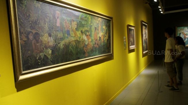 Pengunjung melihat lukisan yang dipajang pada Pameran Seni Koleksi Istana Kepresidenan Republik Indonesia di Galeri Nasional, Jakarta, Sabtu (4/8). Pameran bertema "Indonesia Semangat Dunia" dalam rangka menyambut HUT RI tersebut berlangsung pada 3-31 Agustus 2018. Pameran tersebut memamerkan karya lukisan, patung, kristal, kriya dan arsip terkait gambaran kisah perjuangan atau kepahlawanan yang mengekspresikan semangat bangsa Indonesia. [Suara.com/Oke Dwi Atmaja]