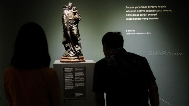 Pengunjung melihat lukisan yang dipajang pada Pameran Seni Koleksi Istana Kepresidenan Republik Indonesia di Galeri Nasional, Jakarta, Sabtu (4/8). Pameran bertema "Indonesia Semangat Dunia" dalam rangka menyambut HUT RI tersebut berlangsung pada 3-31 Agustus 2018. Pameran tersebut memamerkan karya lukisan, patung, kristal, kriya dan arsip terkait gambaran kisah perjuangan atau kepahlawanan yang mengekspresikan semangat bangsa Indonesia. [Suara.com/Oke Dwi Atmaja]