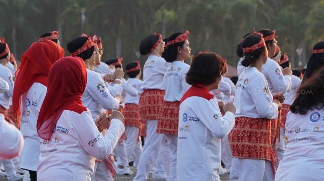 Ribuan peserta melakukan senam poco-poco saat pemecahan rekor dunia Guinness World Records  di Monas, Jakarta, Minggu (5/8). Kegiatan tersebut dalam rangka menyambut Asian Games 2018 itu diikuti 65 ribu peserta dari berbagai kalangan. [suara.com/Muhaimin A Untung]