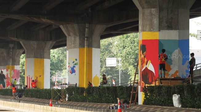 Pelukis membuat mural saat kompetisi mural Citra Marga Nusaphala Persada (CMNP) di sepanjang Jl Layang Tol Rawamangun - Pulogadung, Jakarta, Minggu (5/8). Sebanyak 73 Tiang tol dilukis oleh 200 seniman dari berbagai daerah di Indonesia untuk berpartisipasi dalam ajang kompetisi melukis mural dengan tema Asian Games dan HUT Kemerdekaan Indonesia. [suara.com/Muhaimin A Untung]