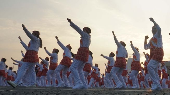 Ribuan peserta melakukan senam poco-poco saat pemecahan rekor dunia Guinness World Records  di Monas, Jakarta, Minggu (5/8). Kegiatan tersebut dalam rangka menyambut Asian Games 2018 itu diikuti 65 ribu peserta dari berbagai kalangan. [suara.com/Muhaimin A Untung]