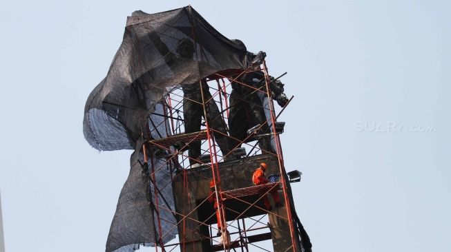 Pekerja membersihkan Monumen Selamat Datang di Bundaran Hotel Indonesia, Jakarta, Minggu (5/8). Perawatan tersebut dilakukan untuk menjaga agar monumen tetap bersih dan menyambut perhelatan Asian Games 2018 yang akan berlangsung pertengahan Agustus bulan ini. [suara.com/Muhaimin A Untung]