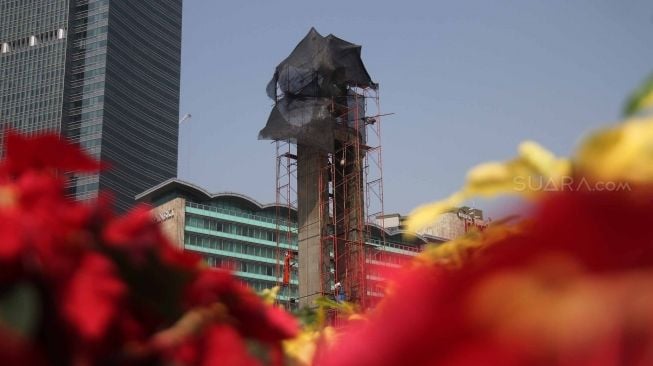 Pekerja membersihkan Monumen Selamat Datang di Bundaran Hotel Indonesia, Jakarta, Minggu (5/8). Perawatan tersebut dilakukan untuk menjaga agar monumen tetap bersih dan menyambut perhelatan Asian Games 2018 yang akan berlangsung pertengahan Agustus bulan ini. [suara.com/Muhaimin A Untung]