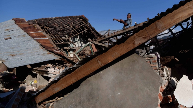 Warga mencari barang berharga miliknya di antara reruntuhan rumahnya yang rusak akibat gempa bumi, Tanjung, Lombok Utara, NTB, Senin (6/8). BNPB mencatat sedikitnya 91 orang korban meninggal dunia akibat bencana gempa bumi yang terjadi Minggu (5/8) dan terdapat kemungkinan akan bertambah. ANTARA FOTO/Zabur Karuru