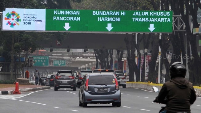 Kendaraan meintas di bawah marka jalan elektronik di Jalan Sudirman, Jakarta, Selasa (7/8). [suara.com/Oke Atmaja]