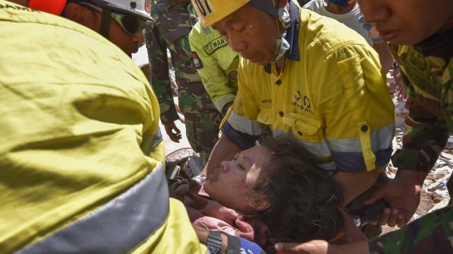 Tim siaga bencana AMNT bersama anggota TNI berusaha mengeluarkan korban selamat dari runtuhan akibat gempa di Desa Pemenang Timur, Kecamatan Pemenang, Tanjung, Lombok Utara, NTB, Selasa (7/8). Korban selamat Nadia Revanala (21) warga Dusun Karang Baru berhasil diselamatkan tim setelah tertimbun reruntuhan gempa selama dua hari dua malam.ANTARA FOTO/Ahmad Subaidi