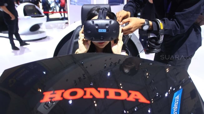 Pengunjung mencoba headset dan peranti VR Honda Sensing di Pameran GIIAS 2018, ICE BSD, Tangerang. [suara.com/Muhaimin A Untung] 