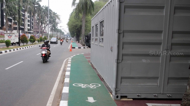 Kendaraan melintas di samping kontainer penjualan tiket Asian Games 2018 yang berada di trotoar Jalan Pintu Satu Senayan, kawasan Gelora Bung Karno (GBK), Jakarta, Rabu (8/8). [Suara.com/Oke Atmaja]
