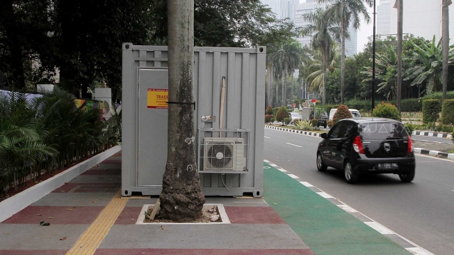 Kendaraan melintas di samping kontainer penjualan tiket Asian Games 2018 yang berada di trotoar Jalan Pintu Satu Senayan, kawasan Gelora Bung Karno (GBK), Jakarta, Rabu (8/8). [Suara.com/Oke Atmaja]
