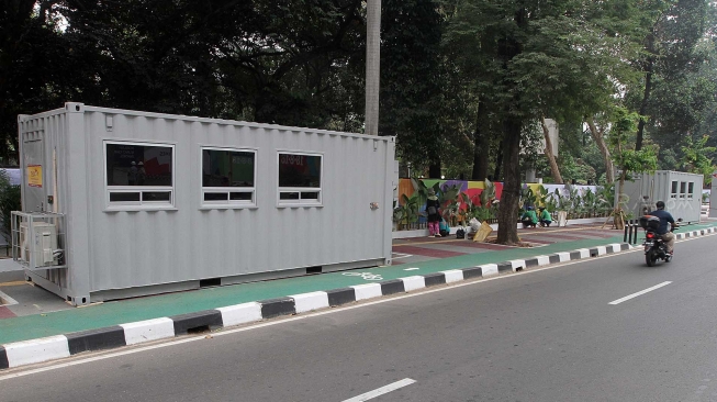 Kendaraan melintas di samping kontainer penjualan tiket Asian Games 2018 yang berada di trotoar Jalan Pintu Satu Senayan, kawasan Gelora Bung Karno (GBK), Jakarta, Rabu (8/8). [Suara.com/Oke Atmaja]