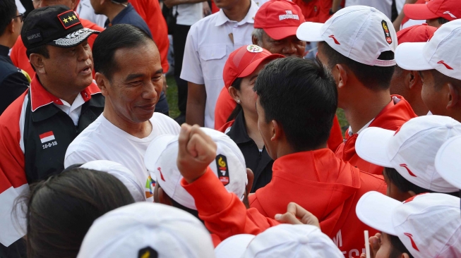 Presiden Joko Widodo (kedua kiri) didampingi CdM kontingen Indonesia, Komjen Pol Syafruddin (kiri) menyalami atlet dan ofisial seusai memimpin upacara pelepasan kontingen Asian Games 2018 di halaman tengah Kompleks Istana, Jakarta, Rabu (8/8). ANTARA FOTO/Wahyu Putro A