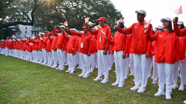 Atlet dan ofisial membawa bendera Merah Putih ketika mengikuti upacara pelepasan kontingen Asian Games 2018 di halaman tengah Kompleks Istana, Jakarta, Rabu (8/8). ANTARA FOTO/Wahyu Putro A