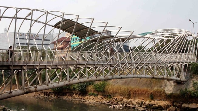 Warga berjalan di Jembatan Penyebrangan Orang (JPO) Jayakarta di kawasan Manggarai, Jakarta, Kamis (9/8). [Suara.com/Oke Atmaja]