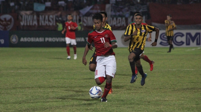 Pemain timnas Indonesia Muhammad Supriadi meneror pertahanan Malaysia dalam pertandingan semifinal yang berlangsung di Stadion Gelora Delta Sidoarjo, Kamis (9/8/2018) [Suara.com/Dimas Angga P]