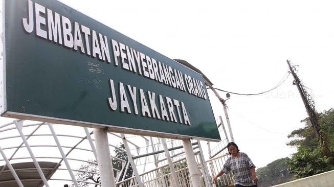 Warga berjalan di Jembatan Penyebrangan Orang (JPO) Jayakarta di kawasan Manggarai, Jakarta, Kamis (9/8). [Suara.com/Oke Atmaja]