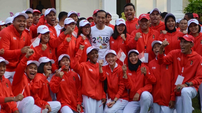 Presiden Joko Widodo (tengah) berfoto dengan atlet dan ofisial atletik seusai memimpin upacara pelepasan kontingen Asian Games 2018 di halaman tengah Kompleks Istana, Jakarta, Rabu (8/8). ANTARA FOTO/Wahyu Putro A