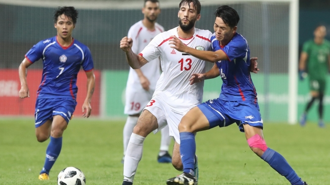 Pesepakbola Palestina, Shehab Qumbor (tengah), berebut bola dengan pemain Cina Taipei, Minghsiu, pada babak penyisihan Grup A cabang sepakbola Asian Games 2018 di Stadion Patriot Bekasi Jawa Barat, jumat (10/8/2018). [Dok. INASGOC]