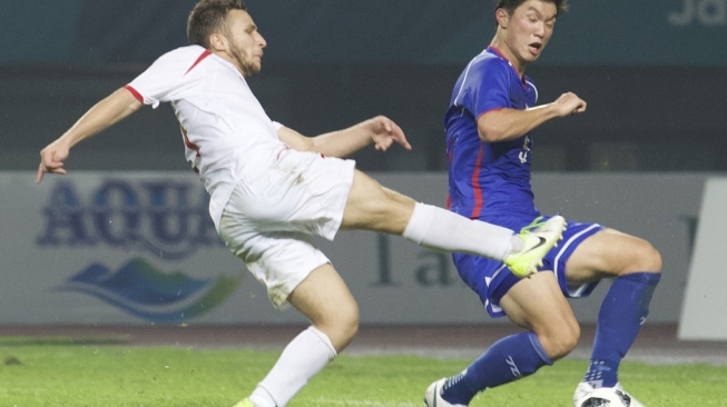 Pemain sepakbola Palestina, Alsharif Omar (kiri) melepaskan tembakan saat diadang pemain Cina Taipei, Huang Hsiangche, pada babak penyisihan Grup A cabang sepakbola Asian Games 2018 di Stadion Patriot Bekasi, Jawa Barat, Jumat (10/8/2018). [Dok. INASGOC]