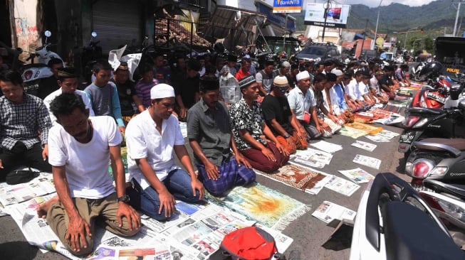 Warga korban gempa melaksanakan salat Jumat di sekitar tempat pengungsian Pemenang, Lombok Utara, NTB, Jumat (10/8). ANTARA FOTO/Zabur Karuru