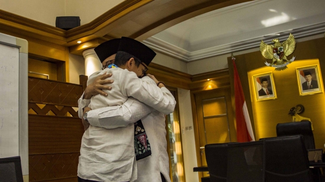 Gubernur DKI Jakarta Anies Baswedan (kanan) berpelukan dengan Sandiaga Uno (kiri) usai pengunduran diri Sandiaga sebagai Wagub DKI Jakarta di Balai Kota, Jakarta, Jumat (10/8). ANTARA FOTO/Galih Pradipta