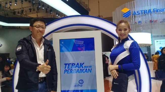 Rudy Chen (kiri) bersama Astra Financial Angel, pemandu games booth Astra Financial di GIIAS 2018 [Suara.com/Imron Fajar].