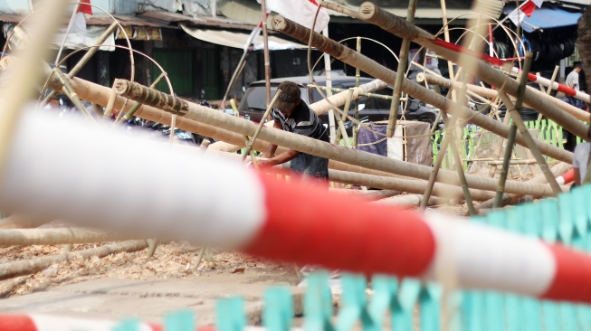 Pedagang menyelesaikan pohon pinang yang akan dijual di kawasan Manggarai, Jakarta, Sabtu (11/8/2018). [Suara.com/Oke dwi Atmaja]