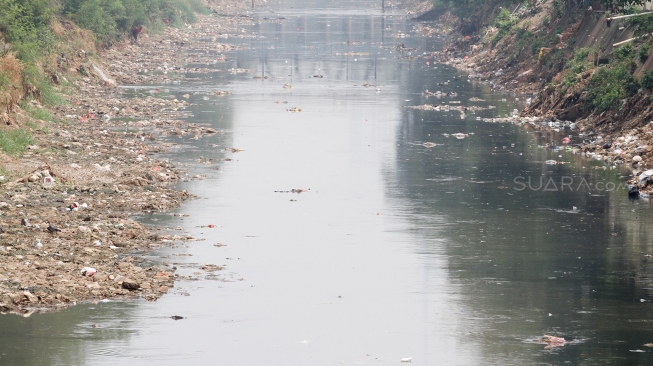 Intensitas hujan yang menurun dan memasuki musim kemarau menyebabkan debit air di sungai ciliwung mengering.[Suara.com/Oke Dwi Atmaja].