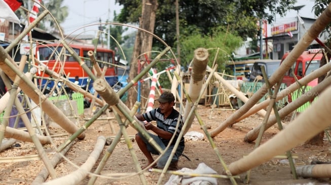 Pedagang menyelesaikan pohon pinang yang akan dijual di kawasan Manggarai, Jakarta, Sabtu (11/8/2018). [Suara.com/Oke dwi Atmaja]