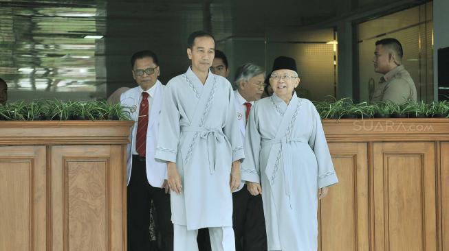 Bakal capres cawapres Pilpres 2019, Joko Widodo dan Ma'ruf Amin menyapa wartawan usai pemeriksaan awal tes kesehatan di RSPAD, Jakarta, Minggu (12/8). [Suara.com/Muhaimin A Untung]