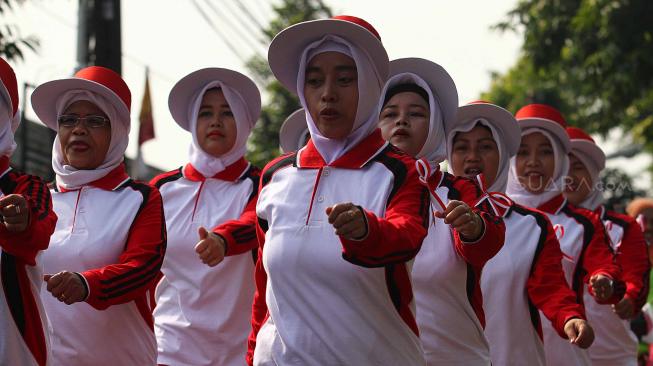 Sejumalah warga mengikuti lomba gerak jalan di kelurahan Kelapa Dua Wetan, Jakarta Timur, Minggu (12/8). Perlombaan tersebut untuk menyambut HUT ke-73 RI. [Suara.com/Muhaimin A Untung]